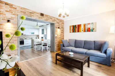 a living room with a blue couch and a brick wall at House Stepic in Sava