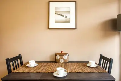 a wooden table with two cups and a vase on it at House Stepic in Sava