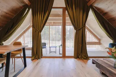 an attic room with curtains and a table at PIRA HOTEL in Postojna