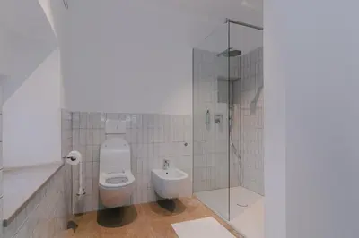 a bathroom with a toilet and a glass shower at PIRA HOTEL in Postojna