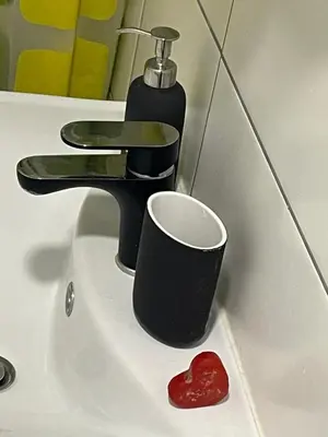 a bathroom sink with a cup and a faucet at ICE APARTMENT in Ljubljana