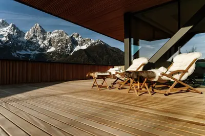 two chairs on a deck with mountains in the background at Chalet Sofija in Gozd Martuljek
