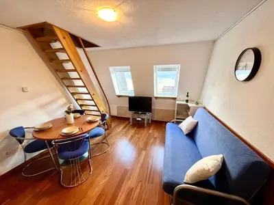 a living room with a table and a blue couch at Apartment Anka in Bovec