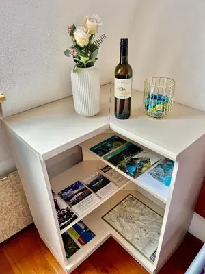 a white shelf with a bottle of wine and a vase at Apartment Anka in Bovec
