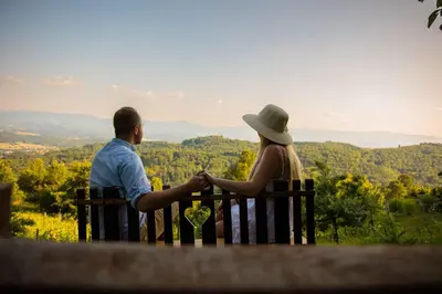 a man and woman sitting on a bench looking at the view at Holiday home in Srednje Grcevje - Kranjska Krain 26095 in Srednje Grčevje
