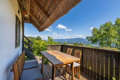 a wooden table and chairs on a deck with a view at Holiday home in Srednje Grcevje - Kranjska Krain 26095 in Srednje Grčevje
