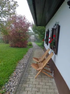 a wooden bench sitting on the side of a house at POČITNIŠKA HIŠA PRLEČKA in Miklavž pri Ormožu