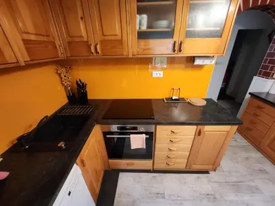 a small kitchen with wooden cabinets and a sink at Apartma CIK in Bovec