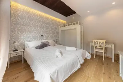 a bedroom with a large white bed and a desk at Farm Stay Ivankotovi in Prem