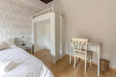 a bedroom with a bed and a desk and a bed and a chair at Farm Stay Ivankotovi in Prem