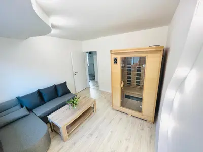 a living room with a blue couch and a table at Luxe Apartments in Ljutomer