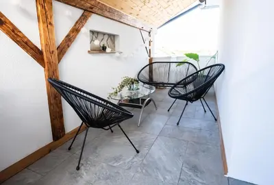 two chairs and a table on a balcony at Luxe Apartments in Ljutomer
