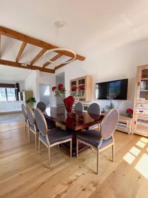 a dining room with a wooden table and chairs at Vila Maister in Celje