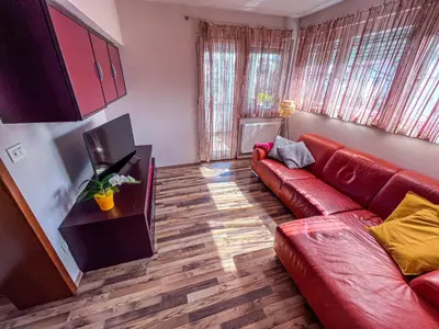 a living room with a red couch and a television at Marta's Place in Nova Gorica