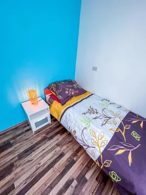 a small bedroom with a bed and a night stand at Marta's Place in Nova Gorica