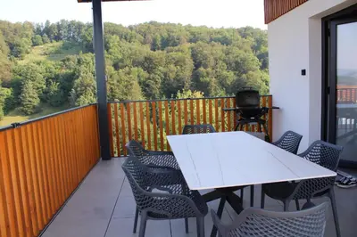 a white table and chairs on a balcony with a view at Villa Strtenica in the vineyard in Pristava pri Mestinju