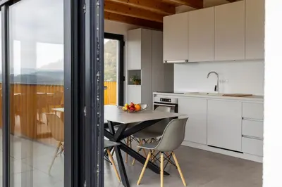 a kitchen with white cabinets and a table and chairs at Villa Strtenica in the vineyard in Pristava pri Mestinju