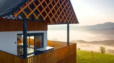 a house with a balcony with a view of the mountains at Villa Strtenica in the vineyard in Pristava pri Mestinju