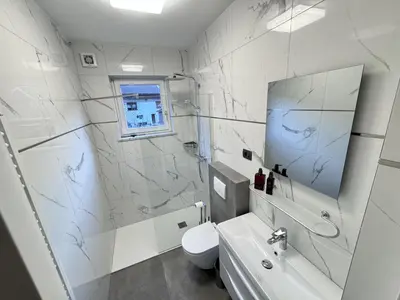 a white bathroom with a toilet and a sink at Apartments & wellness Kal Koritnica in Bovec
