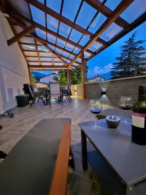 two wine glasses sitting on a table on a patio at SMARAGD Damir Antunovic-sobodajalec in Kobarid