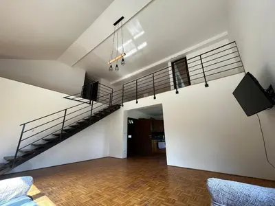 a living room with a spiral staircase in a house at Rooms and apartments Biš in Trnovska Vas