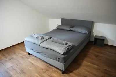 a bed with two pillows on it in a bedroom at Rooms and apartments Biš in Trnovska Vas