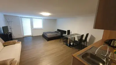 a living room with a bed and a table and a kitchen at Rooms and apartments Biš in Trnovska Vas