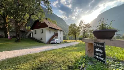 a sign in front of a house with a guest barn at Apartments Mala Korita Soče in Soča