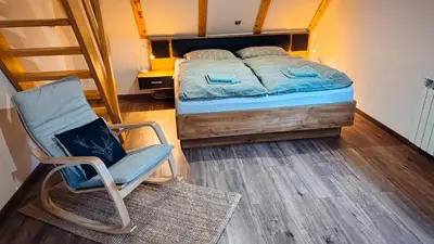 a bedroom with a bed and a rocking chair at Apartments Mala Korita Soče in Soča