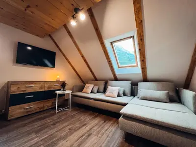 a living room with two couches and a flat screen tv at Apartments Mala Korita Soče in Soča