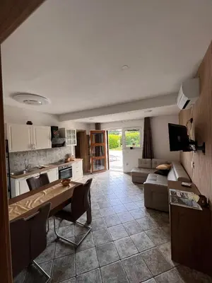 a kitchen and living room with a table and a couch at Spacious apartment in nature with sauna! in Postojna