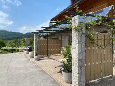 a building with a wooden fence and potted plants at Spacious apartment in nature with sauna! in Postojna