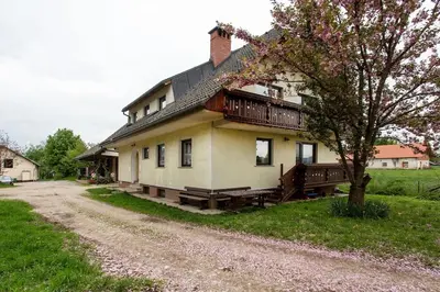 a house on a dirt road next to a tree at Farmhouse Apartment Happy Cow in Mavčiče