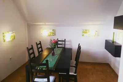 a dining room with a black table and chairs at Farmhouse Apartment Happy Cow in Mavčiče