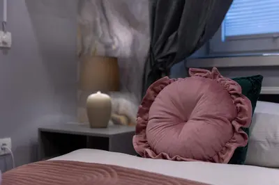 a bedroom with a pink pillow on a bed at MM Rooms in Bled