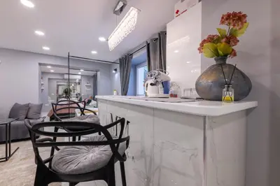a kitchen with a counter with chairs and a vase with flowers at MM Rooms in Bled