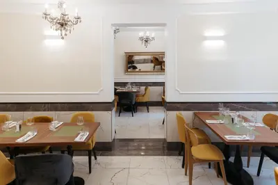 a dining room with wooden tables and yellow chairs at Hotel Švicarija - Terme Dobrna in Dobrna
