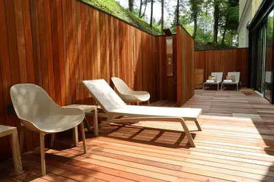 a group of chairs and tables on a wooden deck at Hotel Švicarija - Terme Dobrna in Dobrna