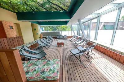 a deck with chairs and tables on a cruise ship at Hotel Švicarija - Terme Dobrna in Dobrna