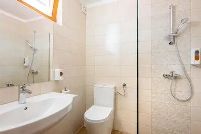 a bathroom with a shower and a toilet and a sink at Terme Banovci - Hotelsko naselje Zeleni gaj in Banovci