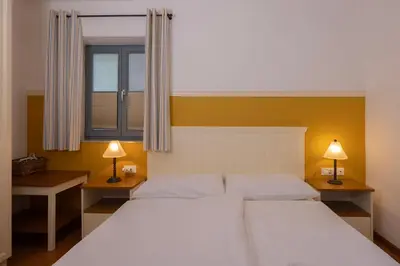 a bedroom with two beds and a window and two lamps at Lakeside Apartments Bled in Bled