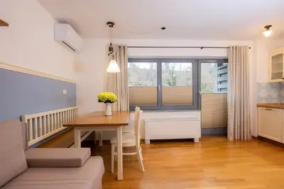 a kitchen and dining room with a table and a window at Lakeside Apartments Bled in Bled