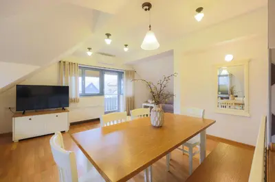 a dining room with a table and a television at Lakeside Apartments Bled in Bled
