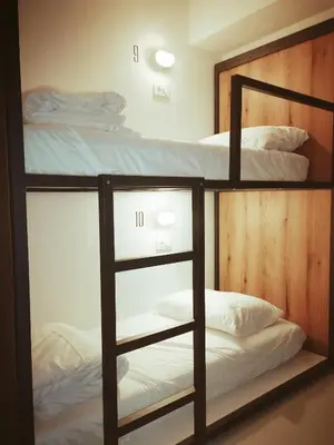 a bedroom with two bunk beds with white sheets at GARAGE HOSTEL in Nova Gorica
