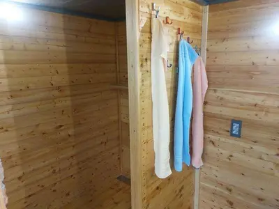 a wooden room with a wooden wall with towels at Glamping na podeželju in Lutverci