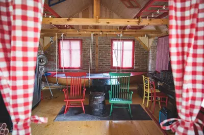 a room with chairs and a table and windows at Glamping na podeželju in Lutverci