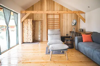 a living room with a couch and a chair at Glamping na podeželju in Lutverci