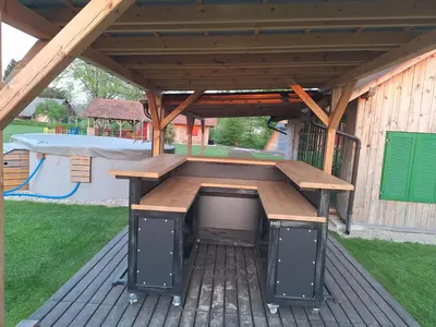 a picnic table under a pavilion with a playground at Glamping na podeželju in Lutverci