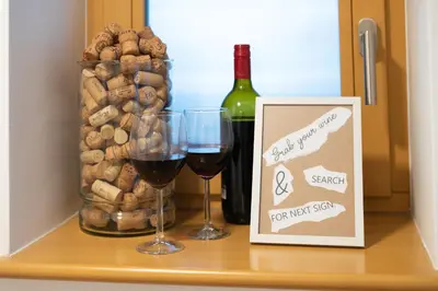 a shelf with two glasses of wine and a bottle of wine at Home Away From Home in Radovljica