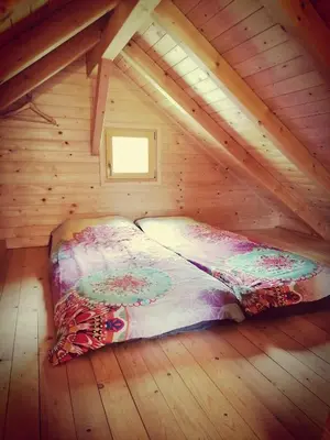 a bed in a wooden room in a attic at Jelenova lesena hiška in Loče pri Poljčanah